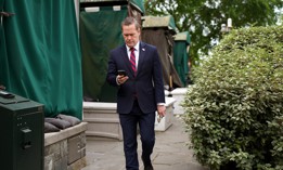 Then-National Security Advisor Michael Waltz looks at his phone as he prepares for a TV interview at the White House on May 01, 2025 in Washington, DC. The Signal clone Waltz used to message other officials shut down services Monday following a reported hack.